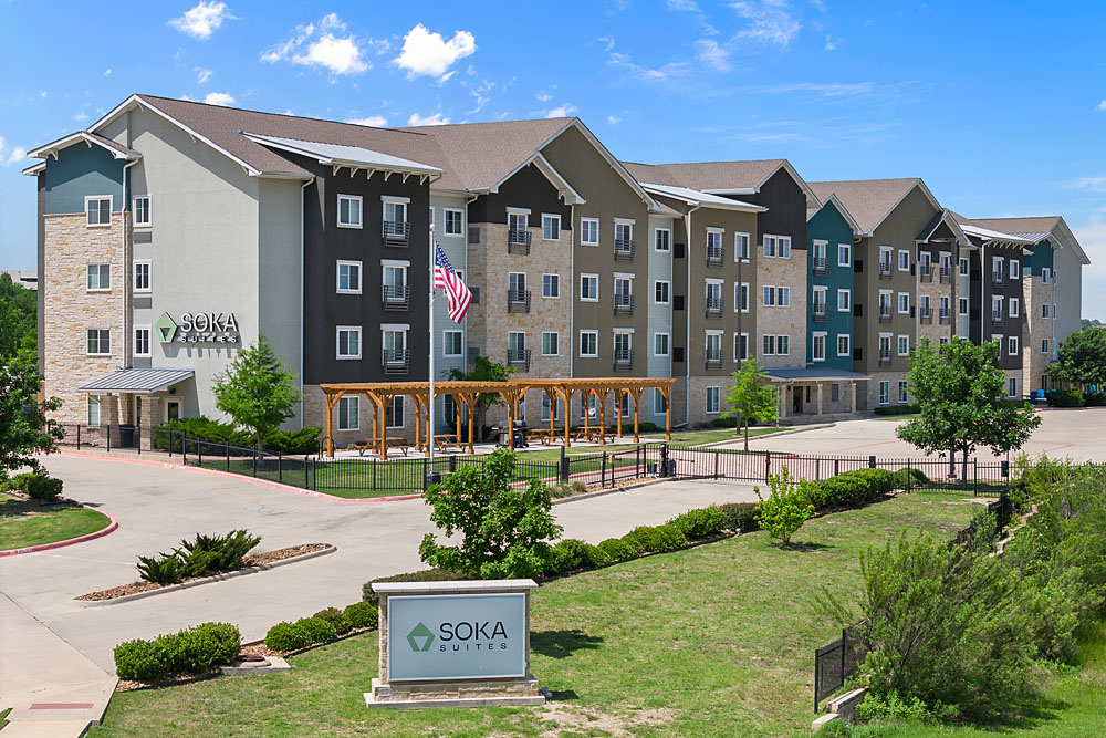Aerial view of Soka Suites in Las Colinas, TX, with clear skies and modern architecture